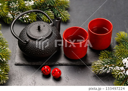 Christmas tea setting with teapot, cups, and fir tree branches 133497224