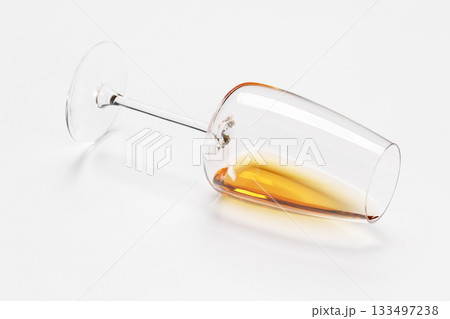 Wine glass with white wine lying on white background 133497238