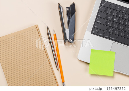 Blank notepad, laptop and stationery on beige workspace, top view with copy space 133497252