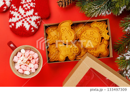 Gingerbread cookies, cup with marshmallows and snowy fir branches 133497309