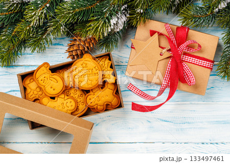 Gingerbread cookies, gift box and snowy fir branches 133497461