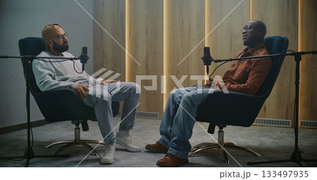 Male Speakers Recording Exclusive Interview For Podcast Sitting in Comfortable Armchairs Male Speakers Recording Exclusive Interview For Podcast Sitting in Comfortable Armchairs 133497935