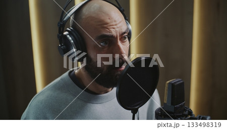 Professional Voice Actor Delivering Expressive Performance in Modern Recording Studio 133498319
