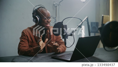 Man Sits at Laptop and Records Professional Dubbing Man Sits at Laptop and Records Professional Dubbing 133498437