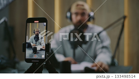 Vertical Phone View Frames Podcast Host Delivering Remarks With Clear Gestures Toward Microphone Vertical Phone View Frames Podcast Host Delivering Remarks With Clear Gestures Toward Microphone 133498514