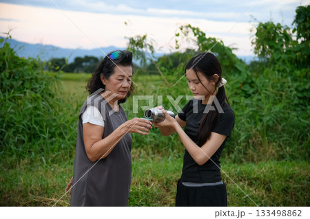 Grandma and granddaughter walk together in the park 133498862