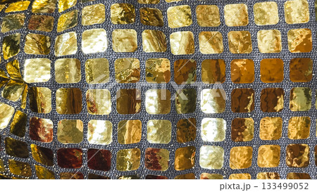 Golden square sequin fabric macro background. Shimmering mosaic texture for luxury party and holiday design Golden square sequin fabric macro background. Shimmering mosaic texture for luxury party and holiday design 133499052