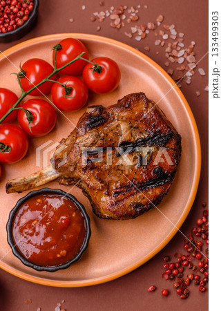 Steak, beef or pork on the bone, meat cooked on the grill with rosemary. Steak on the bone Steak, beef or pork on the bone, meat cooked on the grill with rosemary. Steak on the bone 133499303