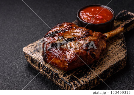 Steak, beef or pork on the bone, meat cooked on the grill with rosemary. Steak on the bone 133499313
