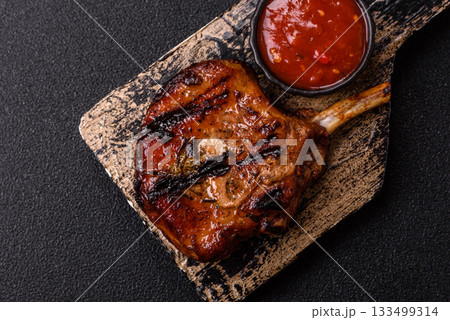 Steak, beef or pork on the bone, meat cooked on the grill with rosemary. Steak on the bone Steak, beef or pork on the bone, meat cooked on the grill with rosemary. Steak on the bone 133499314