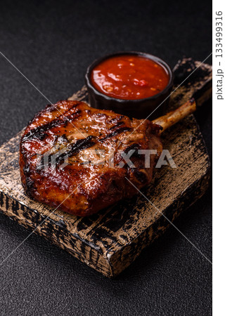 Steak, beef or pork on the bone, meat cooked on the grill with rosemary. Steak on the bone Steak, beef or pork on the bone, meat cooked on the grill with rosemary. Steak on the bone 133499316