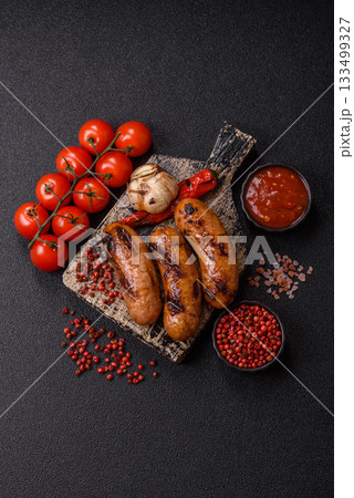 Grilled chicken or beef sausages with sauce and spices. Grilled sausages 133499327