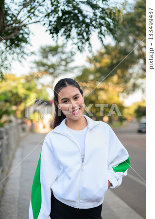 Young Asian Woman in Sporty Casual Outfit Outdoors Young Asian Woman in Sporty Casual Outfit Outdoors 133499437