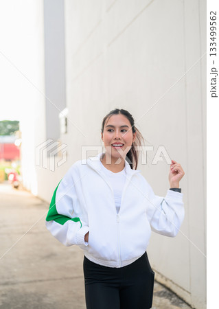 Young Asian Woman in Sporty Casual Outfit Outdoors Young Asian Woman in Sporty Casual Outfit Outdoors 133499562