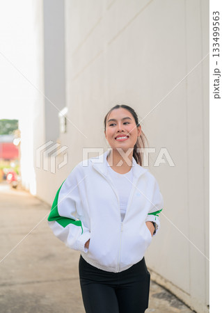 Young Asian Woman in Sporty Casual Outfit Outdoors Young Asian Woman in Sporty Casual Outfit Outdoors 133499563