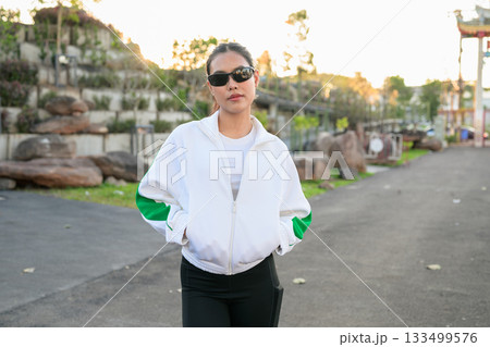 Young Asian Woman in Sporty Casual Outfit Outdoors Wearing Sunglasses 133499576