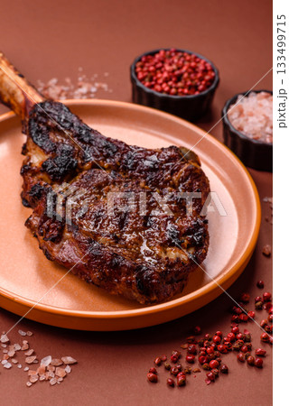 Grilled bone-in meat, beef tomahawk steak, juicy barbecued meat. Tomahawk steak Grilled bone-in meat, beef tomahawk steak, juicy barbecued meat. Tomahawk steak 133499715