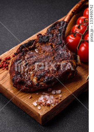 Grilled bone-in meat, beef tomahawk steak, juicy barbecued meat. Tomahawk steak 133499742