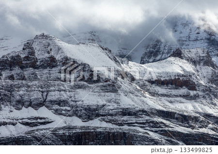 雪の岩山｜雲間から光差す 133499825