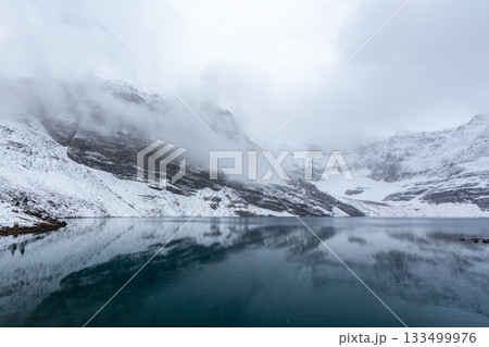 湖面に映る雪山と低い雲 湖面に映る雪山と低い雲 133499976
