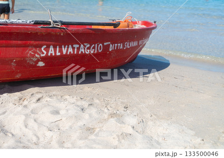 The rescue boat rests near the waters edge, symbolizing lifeguard presence and seaside safety. A strong, recognizable element in beach photography 133500046