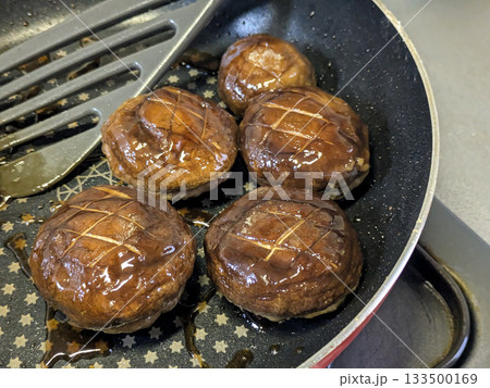 フライパンで焼かれたしいたけの肉詰め料理 美味しい照り焼き味 フライパンで焼かれたしいたけの肉詰め料理 美味しい照り焼き味 133500169