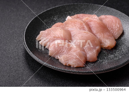 Slices of raw chicken or turkey breast, skinless and boneless. Chicken breast slices 133500964