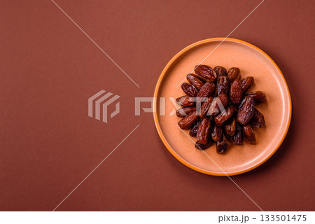Dried dates in a ceramic plate, arabic food for the ramadan table. Dried dates as a food backgrounds Dried dates in a ceramic plate, arabic food for the ramadan table. Dried dates as a food backgrounds 133501475