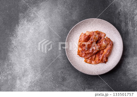 Fried pork bacon slices or strips as a breakfast ingredient. Fried bacon Fried pork bacon slices or strips as a breakfast ingredient. Fried bacon 133501757