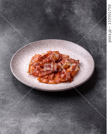 Fried pork bacon slices or strips as a breakfast ingredient. Fried bacon Fried pork bacon slices or strips as a breakfast ingredient. Fried bacon 133501759