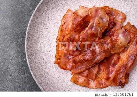 Fried pork bacon slices or strips as a breakfast ingredient. Fried bacon 133501761