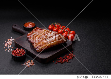 Grilled or barbecued pork or beef ribs with sauce. Cooked or smoked ribs Grilled or barbecued pork or beef ribs with sauce. Cooked or smoked ribs 133502344