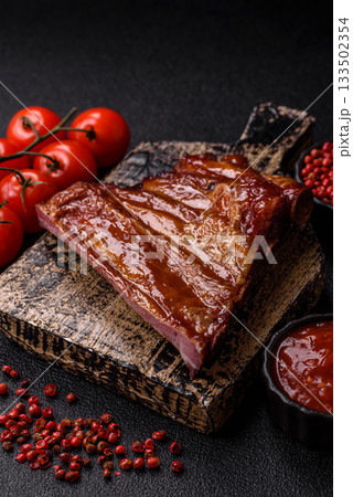 Grilled or barbecued pork or beef ribs with sauce. Cooked or smoked ribs Grilled or barbecued pork or beef ribs with sauce. Cooked or smoked ribs 133502354