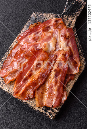 Fried pork bacon slices or strips as a breakfast ingredient. Fried bacon 133502476