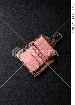 Spiced ham slices, canned meat for lunch sandwiches. Spiced ham as a food background Spiced ham slices, canned meat for lunch sandwiches. Spiced ham as a food background 133502772