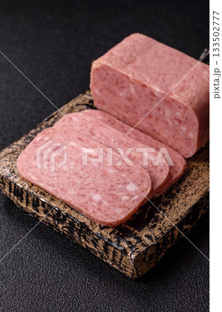 Spiced ham slices, canned meat for lunch sandwiches. Spiced ham as a food background 133502777