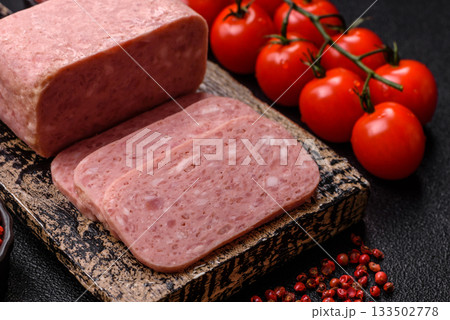 Spiced ham slices, canned meat for lunch sandwiches. Spiced ham as a food background 133502778