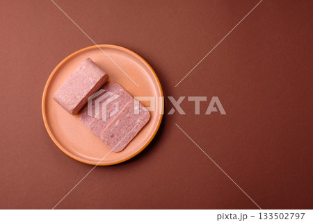 Spiced ham slices, canned meat for lunch sandwiches. Spiced ham as a food background 133502797