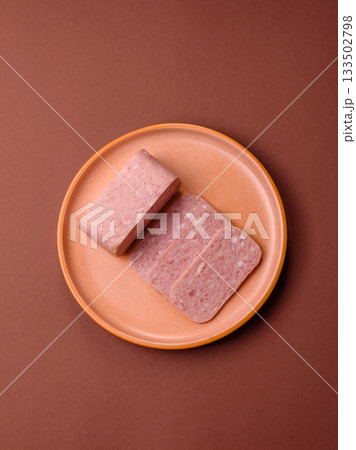 Spiced ham slices, canned meat for lunch sandwiches. Spiced ham as a food background Spiced ham slices, canned meat for lunch sandwiches. Spiced ham as a food background 133502798