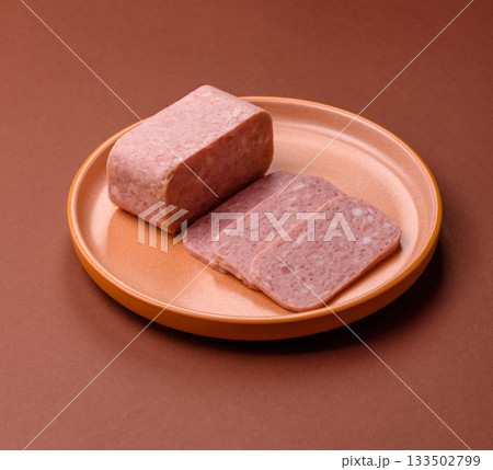Spiced ham slices, canned meat for lunch sandwiches. Spiced ham as a food background Spiced ham slices, canned meat for lunch sandwiches. Spiced ham as a food background 133502799