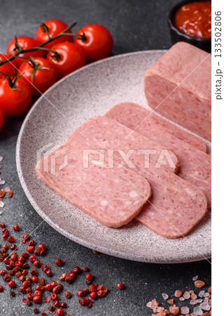 Spiced ham slices, canned meat for lunch sandwiches. Spiced ham as a food background Spiced ham slices, canned meat for lunch sandwiches. Spiced ham as a food background 133502806