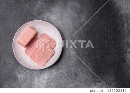 Spiced ham slices, canned meat for lunch sandwiches. Spiced ham as a food background 133502812