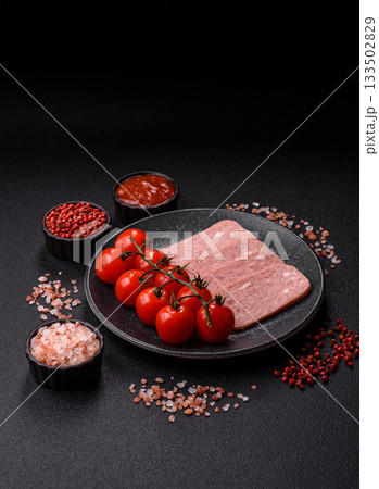 Spiced ham slices, canned meat for lunch sandwiches. Spiced ham as a food background Spiced ham slices, canned meat for lunch sandwiches. Spiced ham as a food background 133502829