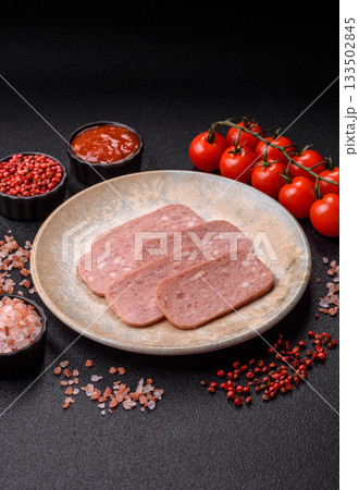 Spiced ham slices, canned meat for lunch sandwiches. Spiced ham as a food background 133502845