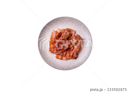 Fried pork bacon slices or strips as a breakfast ingredient. Fried bacon Fried pork bacon slices or strips as a breakfast ingredient. Fried bacon 133502873
