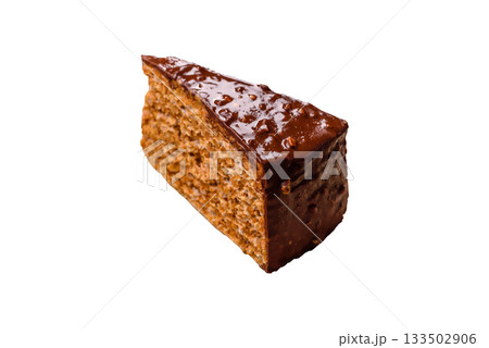 A slice of sweet layered cake covered in chocolate with nuts and caramel. A slice of chocolate cake A slice of sweet layered cake covered in chocolate with nuts and caramel. A slice of chocolate cake 133502906