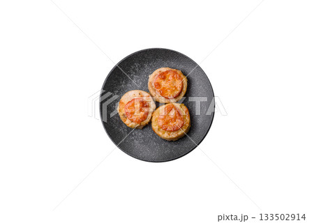 Round fish or chicken cutlets baked with tomato and cheese. Fish cutlets Round fish or chicken cutlets baked with tomato and cheese. Fish cutlets 133502914