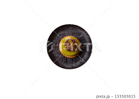 Pistachio cake or tart topped with green mousse with nuts and fruit filling. Pistachio pie 133503015