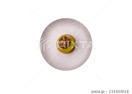Pistachio cake or tart topped with green mousse with nuts and fruit filling. Pistachio pie 133503018
