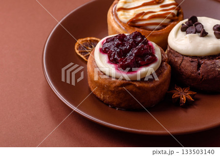 Cinnamon roll, a sweet bun with citrus, cherries, and chocolate, a Danish dessert with cream 133503140